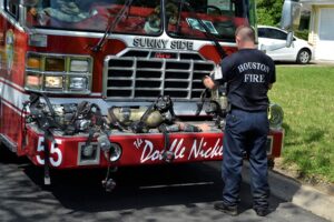 Houston firefighter with fire truck responding to fire alarm systems